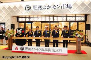 肥後よかモン市場開業を祝いテープカットする東支社長（右から２人目）、田中専務（同３人目）、大西市長（同４人目）ら