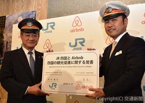 覚書に署名した半井社長（左）と田邉社長