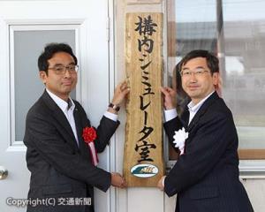 看板を掲げる（左から）内田次長、小川社長