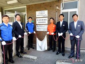 大阪電力MCの発足式で除幕する井上常務（左から２人目）、三津野部長（同５人目）ら＝西日本電気テック提供＝