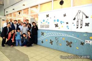 壁面を飾った作品と記念撮影する参加者たち