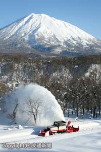 羊蹄山を背に雪を吹き飛ばす排雪モーターカーロータリー（ＪＲ北海道提供）