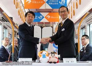 協定書に署名後、固く握手を交わす伊藤支社長（右）と瀧学長（和歌山大学提供）