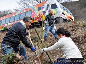 桜の苗木を植える半井社長（左）ら