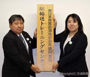 看板を掲げる石田支社長（左）と小崎博子営業部長
