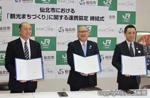 協定書を披露する（右から）菊地支社長、門脇市長、佐藤会長