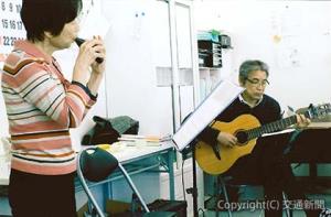 ギター演奏を通じて「元気」を届けている赤坂さん（右）＝日本鉄道ＯＢ会提供＝