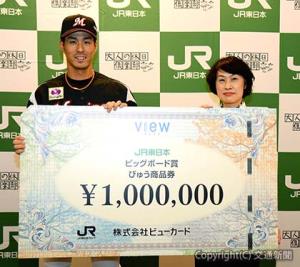 阪本常務執行役員（右）から「びゅう商品券」１００万円ボードを受け取った岡選手