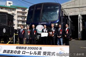 受賞車両の前で記念撮影する須田会長（左から３人目）、千原社長（同４人目）ら