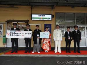 「幸福行き」の乗車券プレートを掲げて記念撮影する石川さん（左から３人目）と長峰さん（同４人目）＝ＪＲ秋田支社提供＝