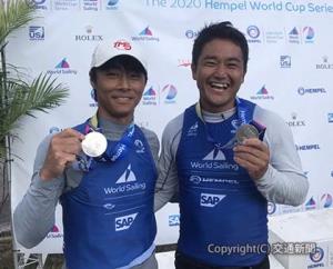 銀メダルを掲げる外薗選手（右）と岡田選手（日本セーリング連盟提供）