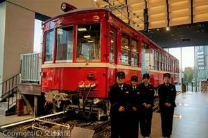 デハ２３０形をバックに立つスタッフ