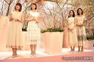 生花装飾されたステージで記念撮影する（左から）垣内さん、鈴木さん、吉田さん、岡本さん