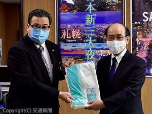 札幌市に防護服を寄贈した村林部長（左）