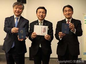 鉄印帳を手にする（右から）堀坂社長、中村副会長、坂元社長