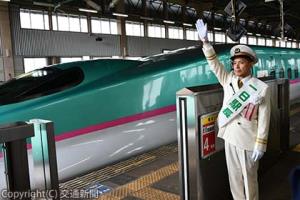 「君は天然色」の発車メロディーが流れる中、一日駅長として出発合図を送る実行委員会の石川さん（ＪＲ盛岡支社提供）