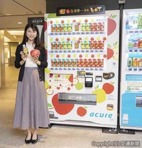 ＪＲ東京駅構内に登場した「りんご自販機」と開発担当の石原さん（ＪＲ東日本ウォータービジネス提供）