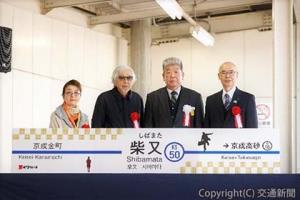 駅名看板とともに記念撮影する（左から）倍賞さん、山田監督、小林社長ら（京成電鉄提供）