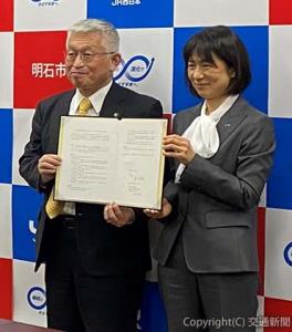 協定書を持つ多田支社長（右）と泉市長（ＪＲ近畿統括本部提供）