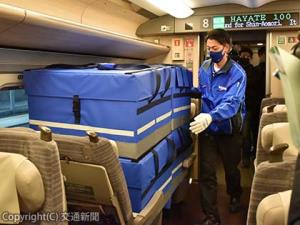新函館北斗駅で新幹線車内に荷物を積み込む佐川急便のスタッフ
