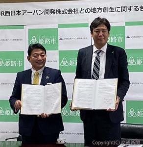 協定書を持つ藤岡社長（右）と清元市長（ＪＲ西日本アーバン開発提供）