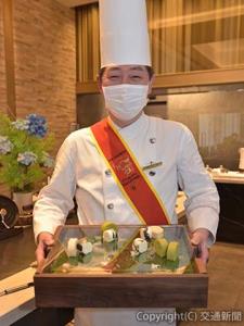 プロジェクトで考案した「牧場ロールケーキ」をＰＲする成田料理長