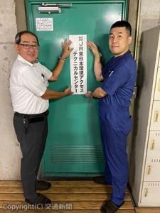 看板を掲げる向山社長（左）と小笠原所長（ＪＲ東日本環境アクセス提供）