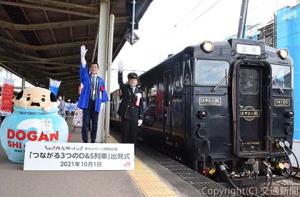 佐賀駅で出発合図を送る石井駅長（右）ら