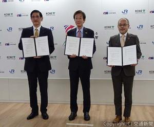 会見後に協定書を掲げる（左から）長谷川社長、久元市長、田中支社長