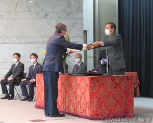 斉藤大臣（右）から表彰状を授与される髙木氏