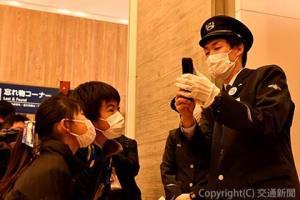 見学ツアーで放送業務を紹介する駅社員