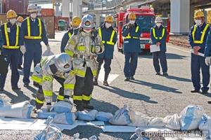 消防署員の説明を受ける訓練参加者（神奈川臨海鉄道提供）