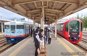 黒部駅に停車中の「一万三千尺物語」（左）と「えちごトキめきリゾート雪月花」（あいの風とやま鉄道提供）