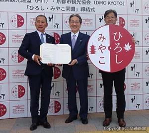 協定締結式で記念撮影する（左から）佐々木会長、田中会長、若菜支社長