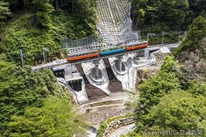 復旧された蛇骨陸橋を走る箱根登山鉄道。線路が山肌を離れて敷設されたことが分かるカット。橋りょう下部には遊歩道が整備され、絶好のフォトスポットになっています（画像提供・箱根登山鉄道）