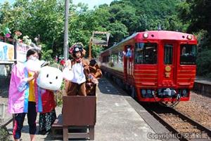 地域の人たちのおもてなしに支えられて走るものがたり列車。「伊予灘ものがたり」８周年のこの日は松岡哲也ＪＲ四国ものがたり列車推進室長（左）も謝意を込めて歓迎に立った（７月24日、予讃線五郎駅）