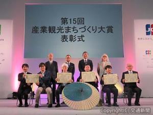受賞者団体の関係者ら。金賞の蒲理事長（前列、右から３人目）はキーコンテンツの一つ、和傘を前に記念撮影