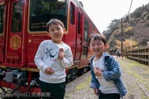 岡山市から乗りに来た樋口晴道君（６）、幸織君（４）は缶バッジを着けて列車の前でにっこり＝ＪＲ四国提供＝