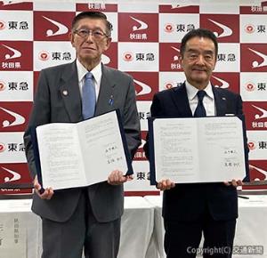 協定書を掲げる髙橋社長（右）と佐竹知事（東急提供）