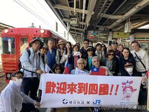 「伊予灘ものがたり」の前で記念撮影する台湾からのツアー客＝松山駅＝（ＪＲ四国提供）