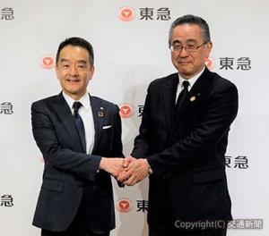 会見後に握手する髙橋社長（左）と堀江取締役