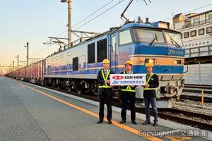 試験輸送で百済貨タに到着した「全農号（仮称）」の前で記念ヘッドマークを手にする（左から）今橋一樹執行役員・関西支社長、上田大介ＪＡ全農米穀部主食課長、佐藤英一全農物流常務（ＪＲ貨物提供）