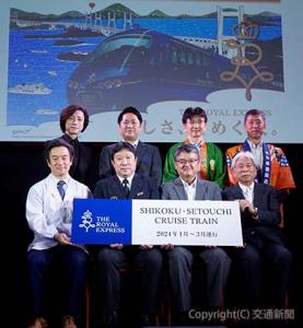 フォトセッションを行う長戸専務（前列右から２人目）、松田部長（同３人目）、水戸岡氏（同右端）ら