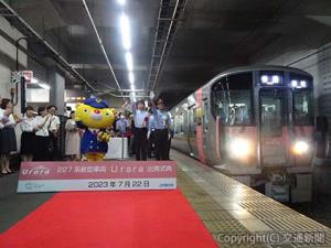 出発合図を行う斉藤駅長(右)、伊原木知事