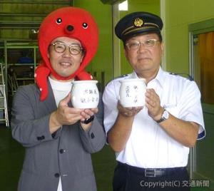 相互乗り入れの証としてタコつぼにサインした竹本社長（右）と柳本副社長（銚子電鉄提供）