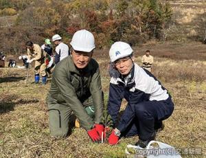 植樹活動に参加した江草社長（右）と外山京太郎村長＝日本リーテック提供＝