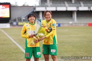 試合後、海外移籍することになったＦＷ千葉（左）の壮行セレモニーが行われ、筑波大学同期のＤＦ蓮輪が花束を贈呈©ＪＥＦＵＮＩＴＥＤ