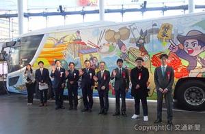 バスの前で記念撮影する飯田社長（左から３人目）、岩本社長（同４人目）、漆原支社長（同５人目）、杉本知事（同６人目）ら