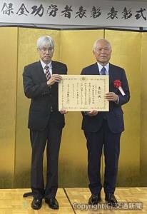 表彰状を贈られた新井会長（右）と和田事務次官=日本鉄道広告協会提供=