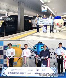 ㊤関西空港駅ホームでフォトセッションを行う田村駅長（左端）と福田駅長（左から２人目）ら㊦テープカットを行う（左から）岡田部長、北林執行役員、徳永さん、吉田部長